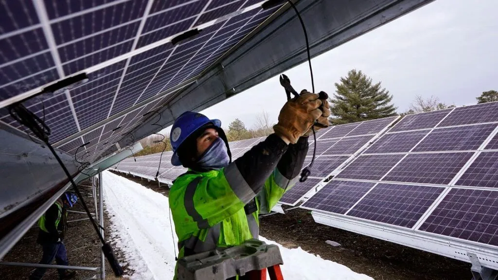 Technician connecting wiring beneath solar array